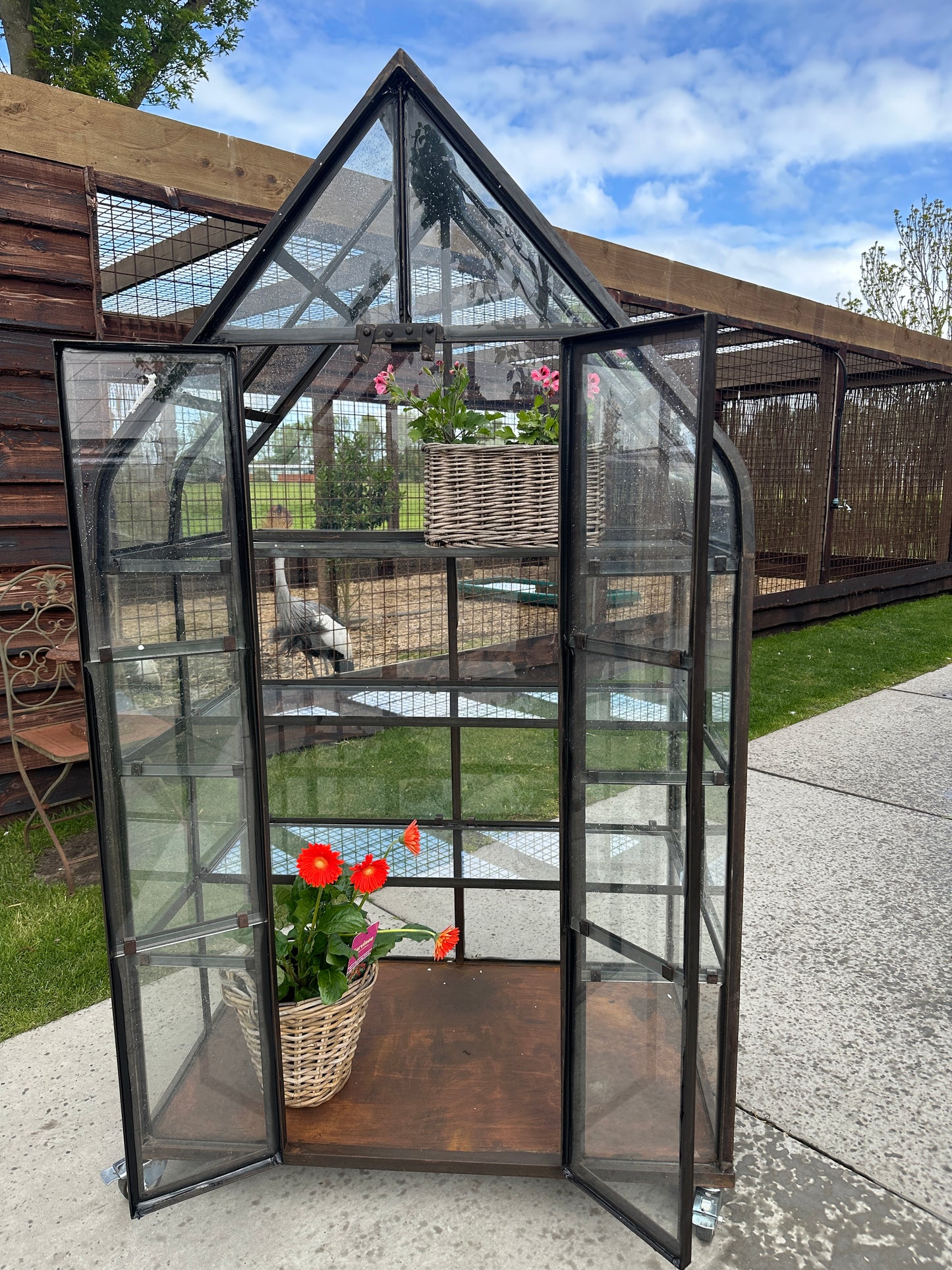 Greenhouse tuinkas op wielen, sfeervol in de tuin
